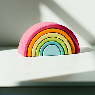 A small toy rainbow sits on a table
